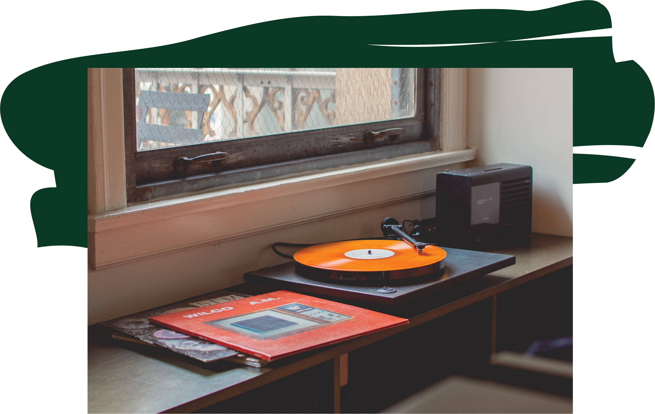 Vinyl and record player near a window